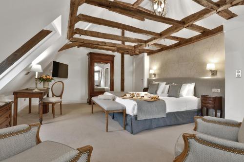 - une chambre avec un lit, une table et des chaises dans l'établissement Château des Vigiers, à Monestier