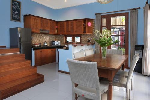a kitchen and dining room with a wooden table and chairs at Sonti Villa in Seminyak