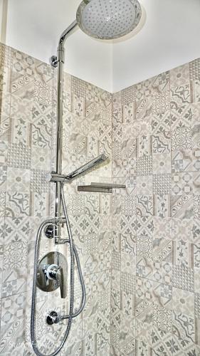 a shower with a shower head in a bathroom at Sweet Home Suite in Fasano