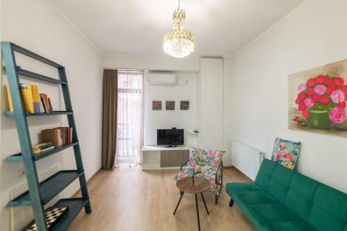 ein Wohnzimmer mit einer grünen Couch und einem Stuhl in der Unterkunft Best Location Apartment in Old Tbilisi in Tbilisi City