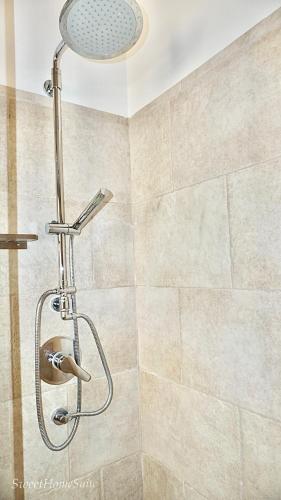 a shower with a shower head in a bathroom at Sweet Home Suite in Fasano