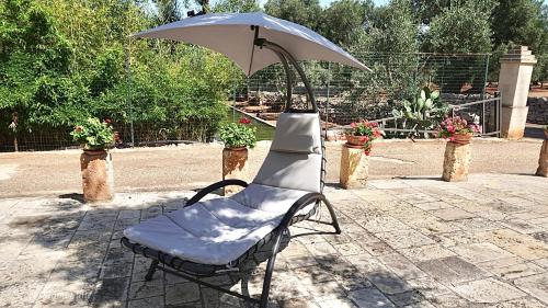 a chair with an umbrella sitting on a patio at Sweet Home Suite in Fasano