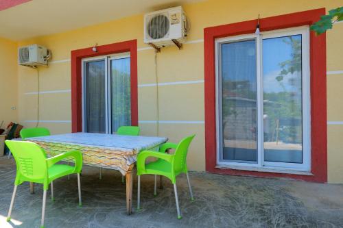a table and chairs on a patio with a window at Ilias House in Ksamil
