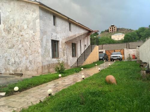 a stone building with a yard with balls on the grass at White House-001 in Yeghegnadzor