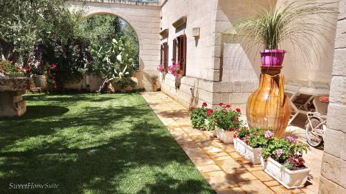 a garden with a large vase filled with plants at Sweet Home Suite in Fasano