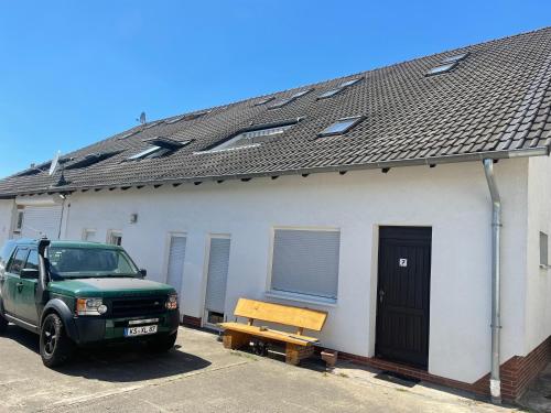 a green truck parked in front of a building at Bed4You Gästehaus 1 in Bergshausen