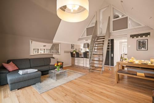 a living room with a couch and a stair case at Wohlfühlloft Seekretzer mit privatem Seezugang in Friedrichshafen