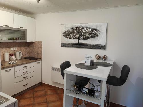 a kitchen with a table and a tree on the wall at Apartman Dunav in Aljmaš