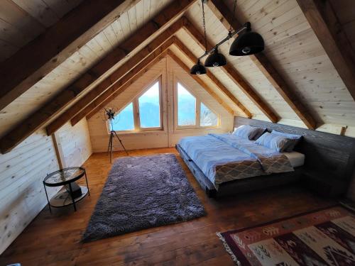 ein Schlafzimmer im Dachgeschoss mit einem Bett und einem großen Fenster in der Unterkunft Villa Skyline in Kotor