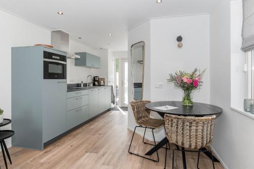 a kitchen with a table and chairs in a kitchen at Vakantiehuis '2bijZee' dicht bij Domburg en strand in Aagtekerke