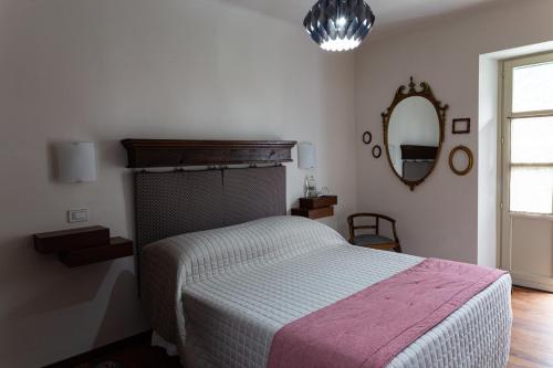 a bedroom with a bed and a mirror on the wall at Maison Flipot in Torre Pellice