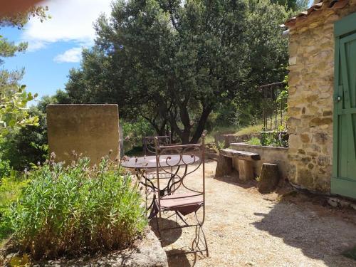 d'une terrasse avec une table et des chaises dans le jardin. dans l'établissement Sous les Chênes, à Peypin-dʼAigues
