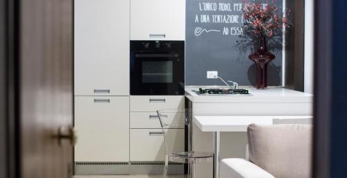 uma cozinha branca com um lavatório e um fogão em APPARTAMENTO LA CAFFETTERIA em Rovereto