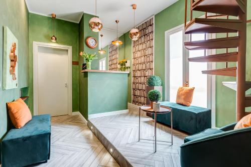 a living room with green walls and a spiral staircase at Ripetta Natural Suites in Rome