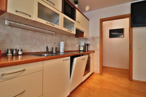 uma cozinha com armários brancos e um lavatório em Apartments Pod Bregom em Kranjska Gora