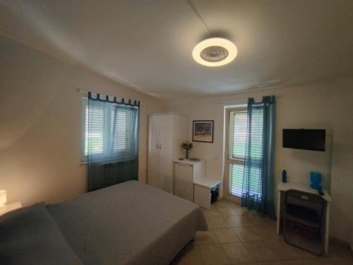 a bedroom with a bed and a desk and a television at Gullo Capo Vaticano in Ricadi