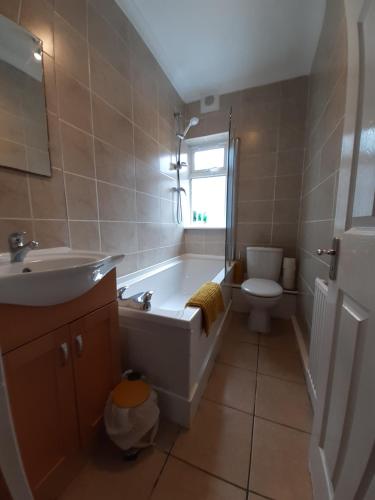 y baño con bañera, aseo y lavamanos. en Carvetii - Xavier House - 2-storey sleeps up to 7, en Rosyth
