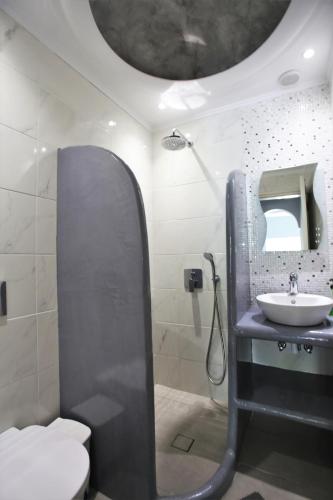 a bathroom with a sink and a toilet and a mirror at Dimitris Villa in Kamari