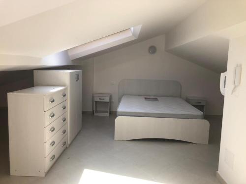 1 dormitorio blanco con 1 cama y vestidor en Calanovella Mare Primo Piano 8, en Piraino