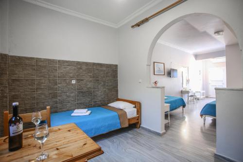 Camera con letto e tavolo con bottiglia di vino di Dimitris Villa a Kamari