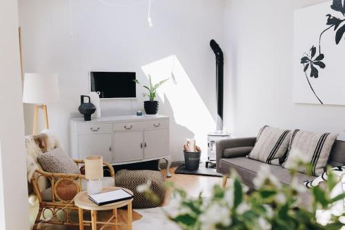 a living room with a couch and a tv at 'The Studio' Designer, seaside cottage in Crawfordsburn