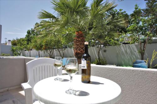 a bottle of wine sitting on a table with two glasses at Dimitris Villa in Kamari