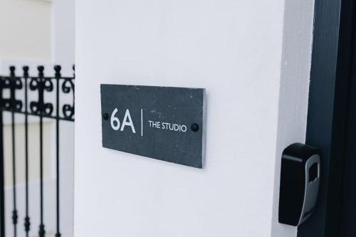 a sign on a wall next to a fence at 'The Studio' Designer, seaside cottage in Crawfordsburn
