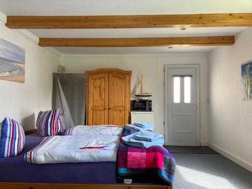 サガルトにあるFerienhäuser Vogelsangのベッドルーム1室(ベッド1台付)、木製キャビネットが備わります。