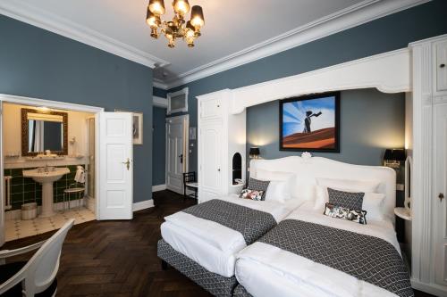 a bedroom with two beds and a sink in it at Hotel Der Kleine Prinz in Baden-Baden