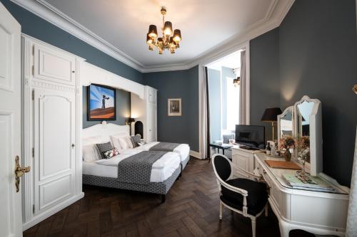 a bedroom with a bed and a desk with a computer at Hotel Der Kleine Prinz in Baden-Baden