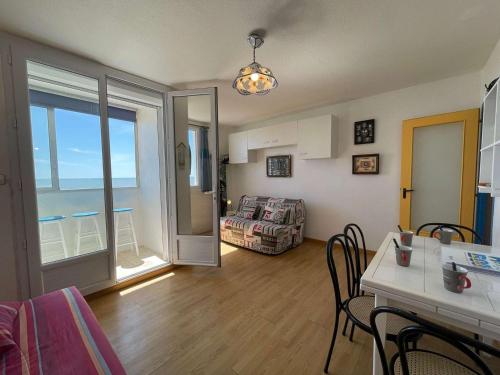 un salon avec un canapé et une table avec des chaises dans l'établissement Studio face à la mer pour 4 personnes avec TV - Ménage inclus - Saint-Hilaire-de-Riez - FR-1-224C-665, à Saint-Hilaire-de-Riez
