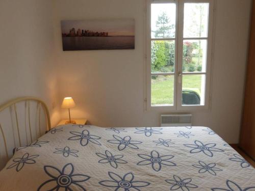 - une chambre avec un lit doté d'un couvre-lit floral et d'une fenêtre dans l'établissement Maison avec piscine chauffée, 4 pièces, 6 couchages près de Saint-Gilles-Croix-de-Vie - FR-1-224-671, à Saint-Révérend