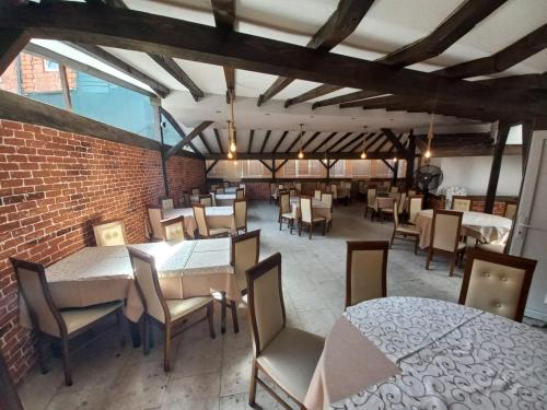 a restaurant with tables and chairs and a brick wall at Hotel Roma in Struga