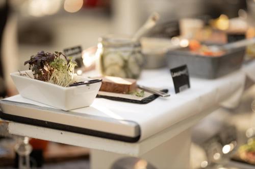a white table with a bowl of food on it at Gränsö Slott Hotel & Spa in Västervik