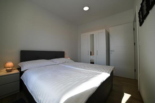 a bedroom with a large bed with white sheets at Apartment Perlitto in Cres