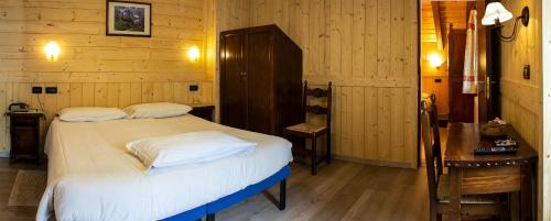 a bedroom with a bed with white sheets and pillows at Santa San in Champoluc
