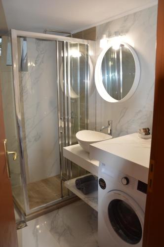 a bathroom with a sink and a washing machine at Sea melody apartments in Stavromenos