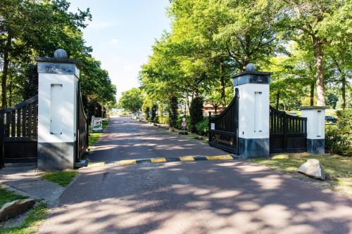 une allée avec un portail et des arbres dans un parc dans l'établissement EuroParcs Limburg, à Susteren