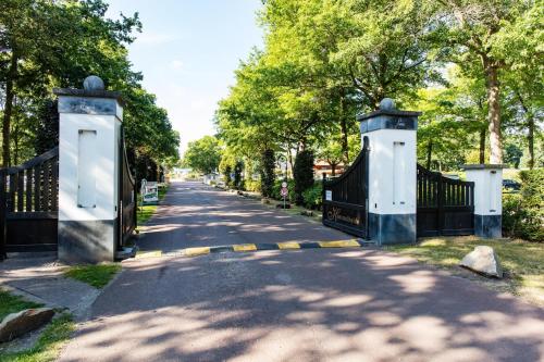 eine Einfahrt mit einem Tor und Bäumen in einem Park in der Unterkunft EuroParcs Limburg in Susteren
