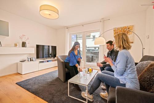 a group of people sitting in a living room at Ferien-Apartment Auenwald - mit priv Strandzugang in Friedrichshafen