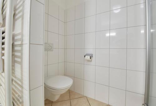 a white bathroom with a toilet and a shower at Chalet Haider in Saalbach Hinterglemm