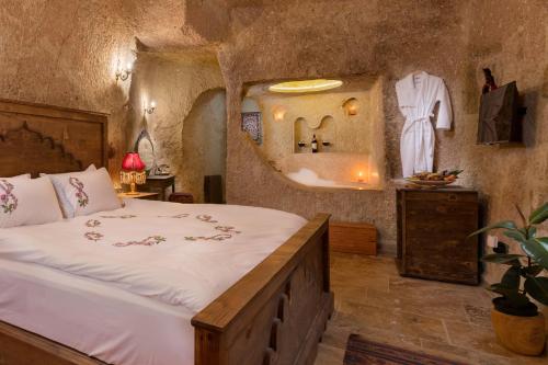 a bedroom with a large bed and a mirror at Kayata Cave Suites Special Class in Urgup
