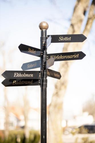 a street sign with arrows pointing in different directions at Gränsö Slott Hotel & Spa in Västervik