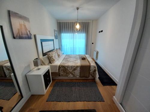 um pequeno quarto com uma cama e um espelho em Precioso apartamento con piscina em Portonovo