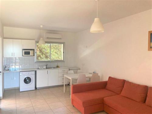 a living room with a red couch and a kitchen at Ariadne Apartments in Paphos City