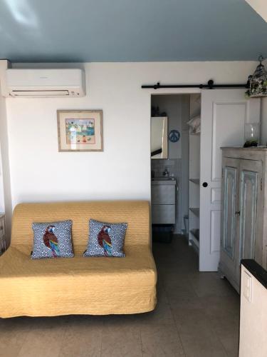 uma sala de estar com um sofá com duas almofadas em La Maisonette Antibes em Antibes