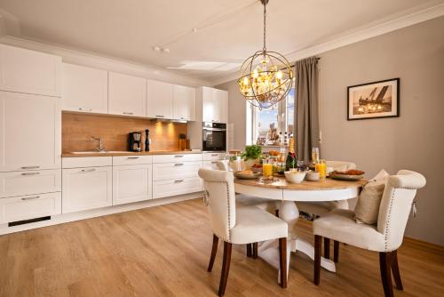 a kitchen with a dining room table and chairs at Ferien-Apartment Sandmuschel - mit priv Strandzugang in Friedrichshafen