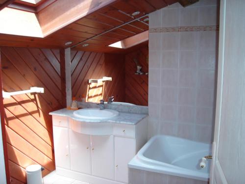 ein Badezimmer mit einem Waschbecken und einer Badewanne in der Unterkunft GITE A LA FERME in Le Pin-Saint-Denis