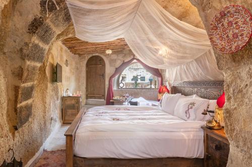 a bedroom with a bed in a stone wall at Kayata Cave Suites Special Class in Urgup
