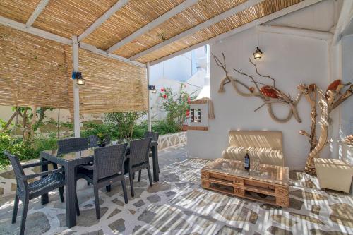 a patio with a table and chairs and a bench at Hotel Antiparos in Antiparos
